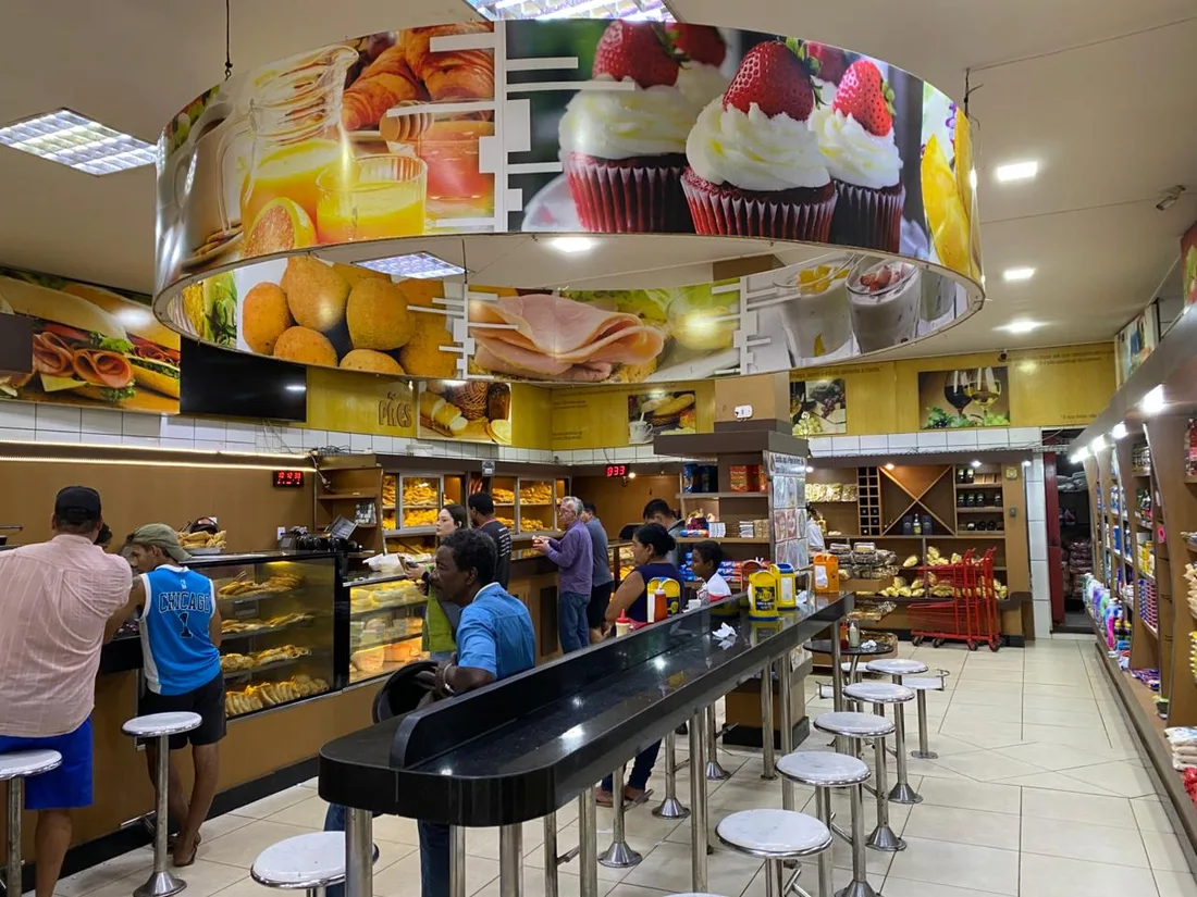 Hall de entrada da Padaria São Francisco, com balcão de vidro e ambiente interno movimentado